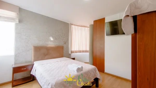 Habitación 4. Espacio elegante y lleno de energía con un vibrante muro de acento color dorado. Disfrute de una cómoda cama queen, amplio espacio de almacenamiento en el armario abierto y un práctico tocador/escritorio. Ideal para parejas que buscan un refugio acogedor con baño privado y smart tv.