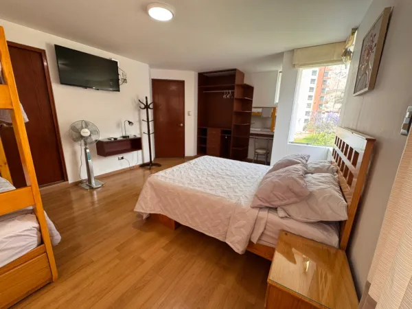 Habitación 5. Espacio elegante y lleno de energía con un vibrante muro de acento color dorado. Disfrute de una cómoda cama queen, amplio espacio de almacenamiento en el armario abierto y un práctico tocador/escritorio. Ideal para parejas que buscan un refugio acogedor con baño privado y smart tv.